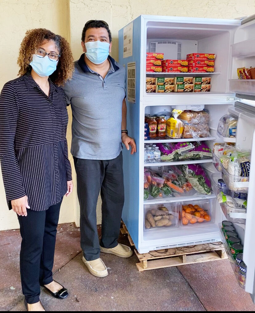 From left: Tamu and Eldred Fourie show the filled Community Fridge.